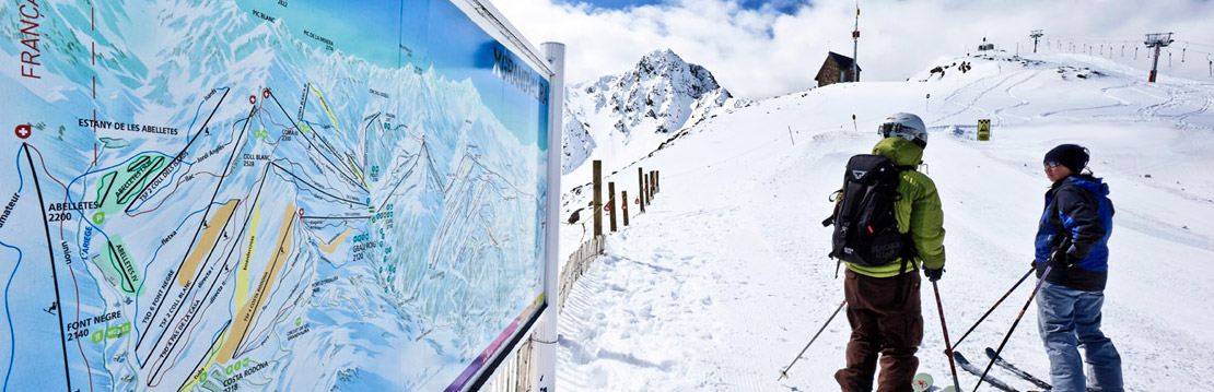 Skiers next to Grandvalira piste map