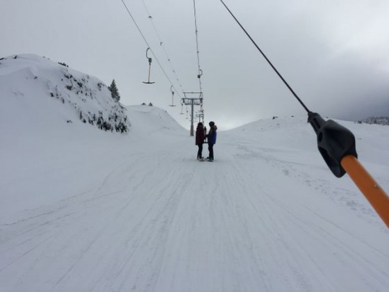 Snowboarders on the drag lift
